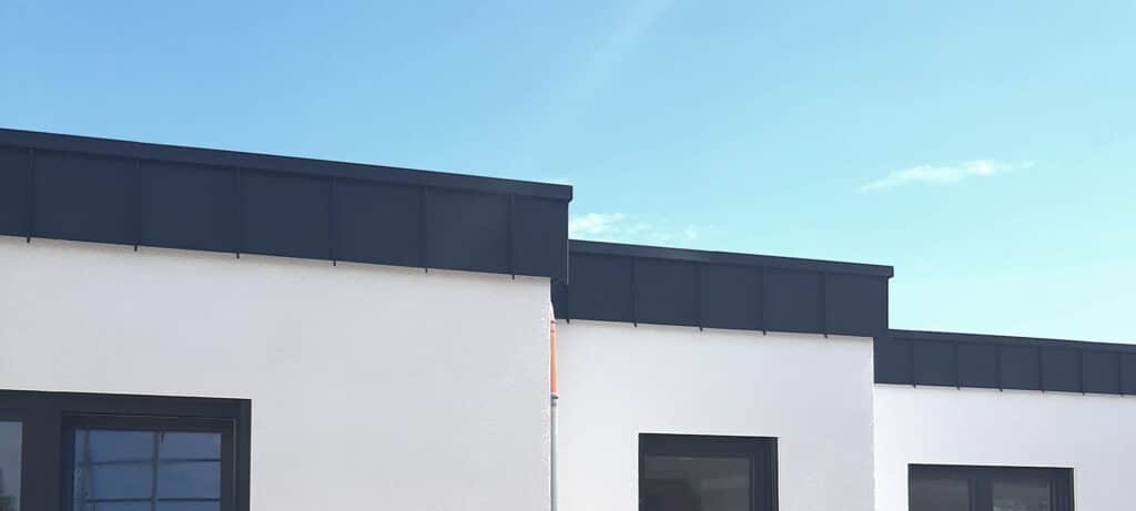 Bungalow mit dunkler Verkleidung der Attika in Köln.