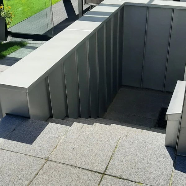 Ein Kellerabgang mit einer Mauerabdeckung und Wandverkleidung aus Zinkblech in Doppelstehfalztechnik.