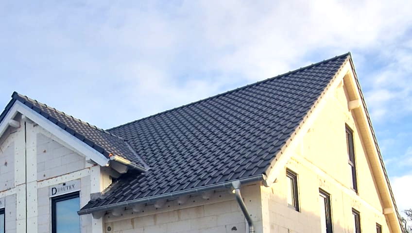 Neubau mit einer Dacheindeckung aus klassischen dunkelbraunen Dachziegeln in Köln.
